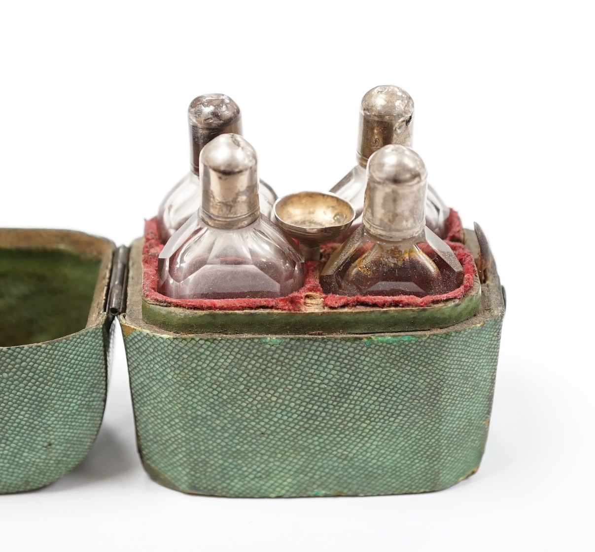 A set of four Dutch white metal mounted scent bottles, with funnel, housed in a shagreen case with hinged cover, case height 69mm.